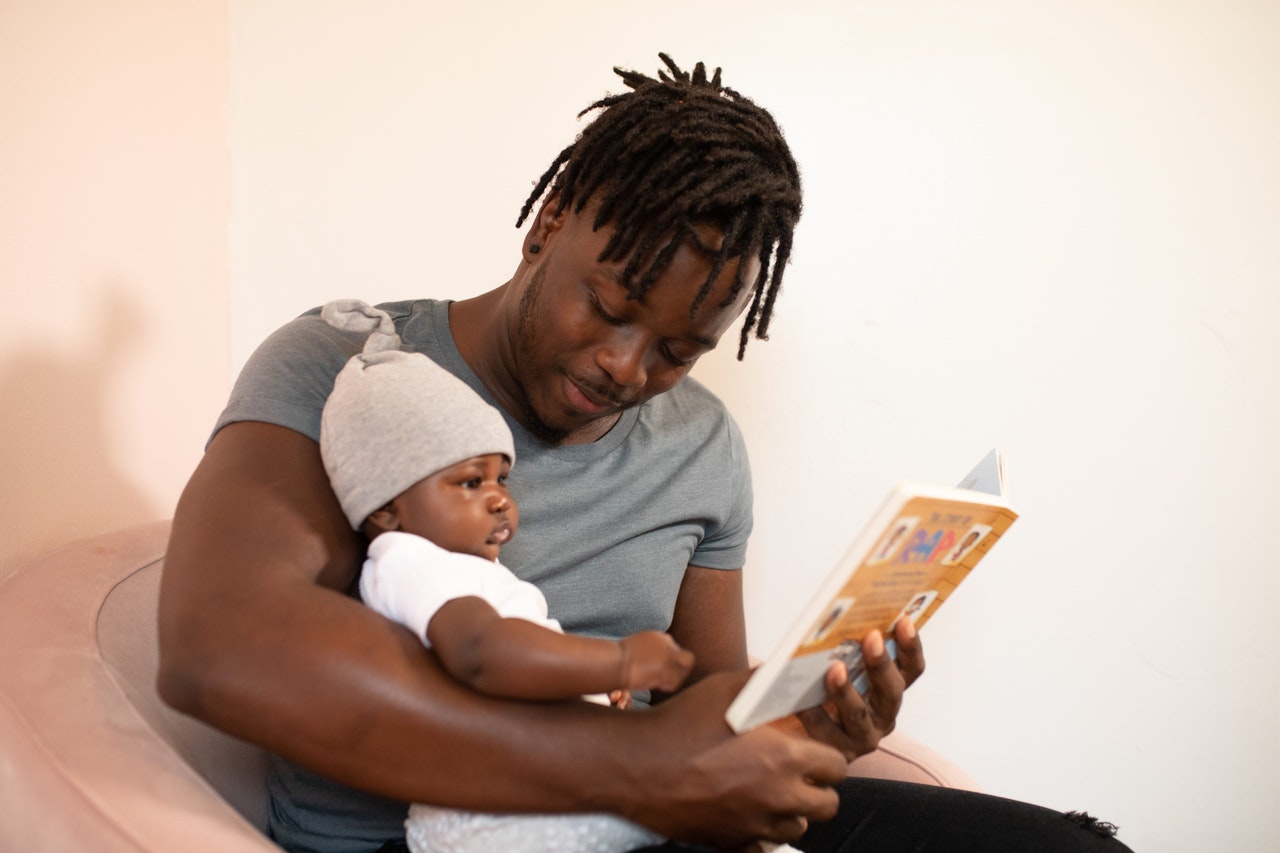 Man in Grey Shirt Reading With Toddler